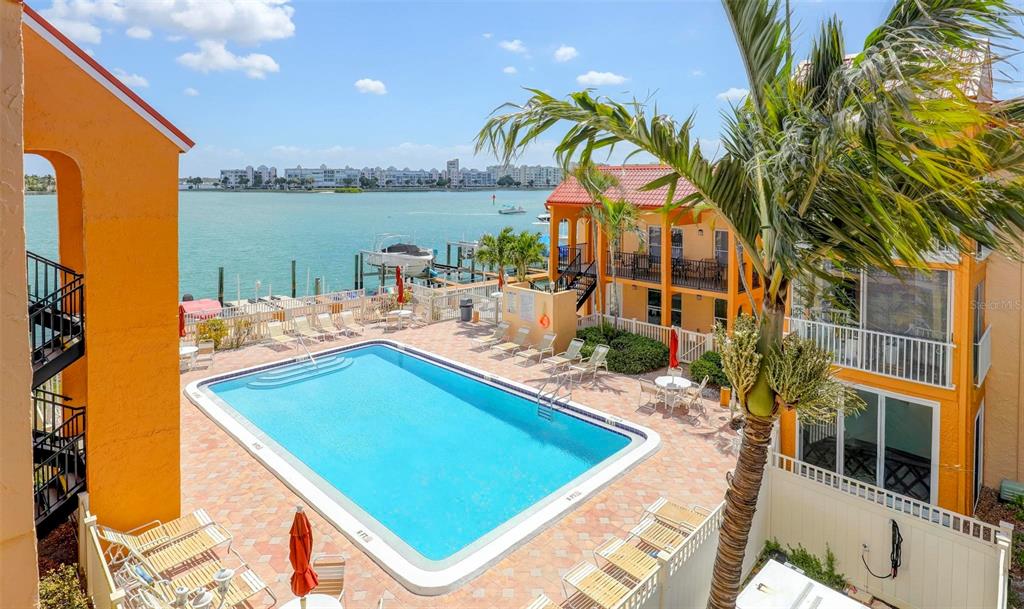 8911 Blind Pass Road, Unit 321 St. Pete Beach, FL 33706 - Photo 47 of 55 a view of a swimming pool with an outdoor seating space