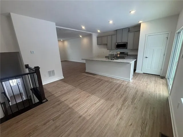 a view of kitchen with sink and refrigerator
