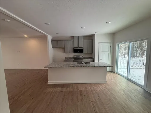 a view of kitchen with microwave and wooden floor