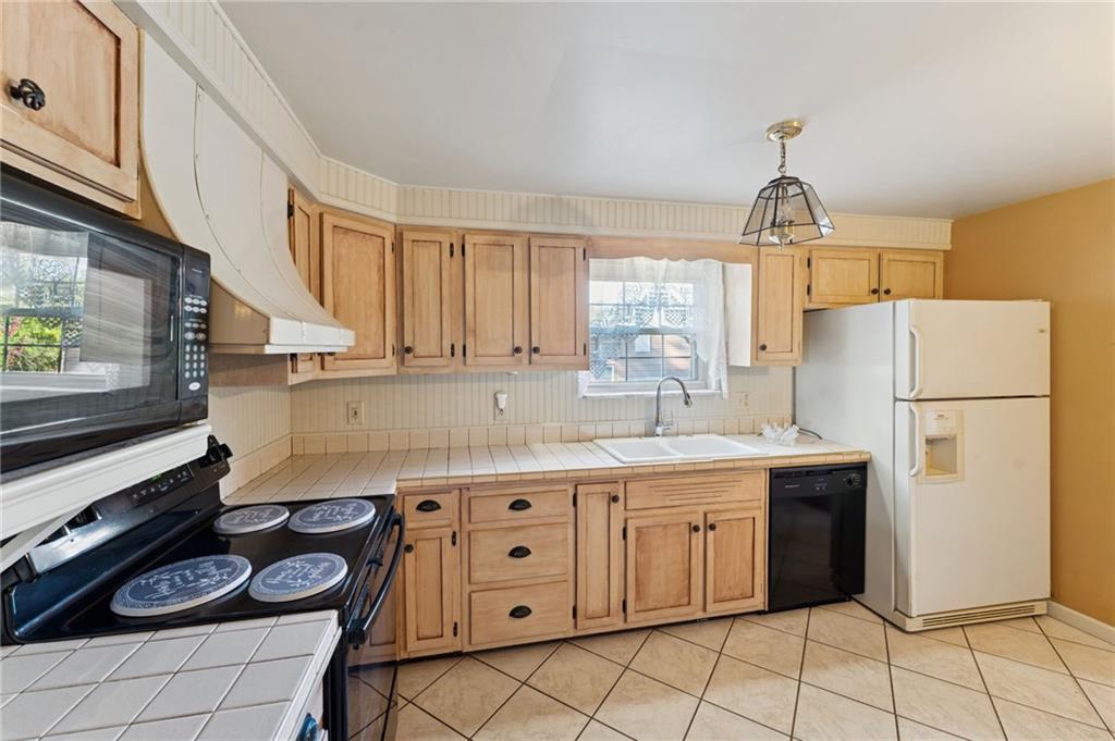 1237 Circle Drive Pittsburgh, PA 15221 - Photo 19 of 40 a kitchen with a sink a stove a refrigerator and cabinets