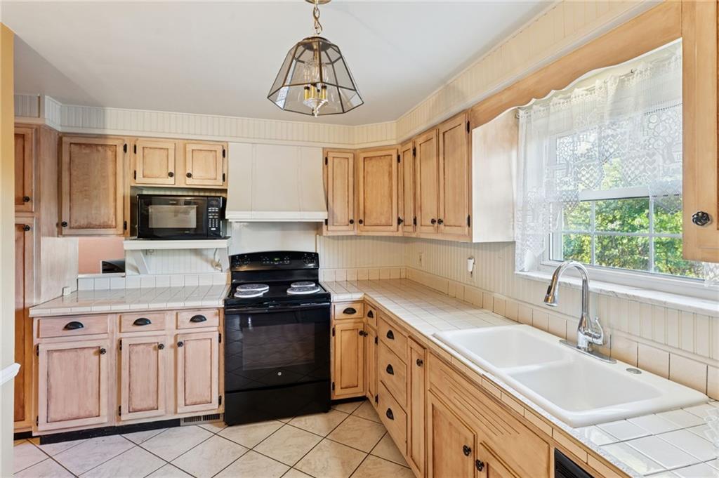 1237 Circle Drive Pittsburgh, PA 15221 - Photo 20 of 40 a kitchen with granite countertop a stove sink and microwave