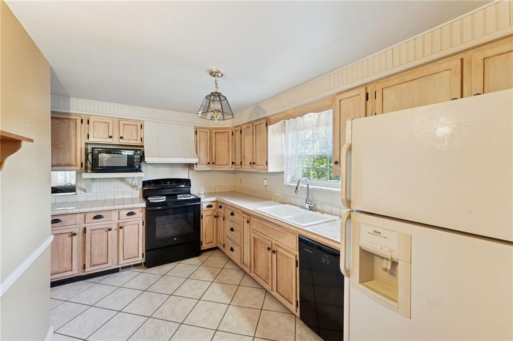 1237 Circle Drive Pittsburgh, PA 15221 - Photo 21 of 40 a kitchen with stainless steel appliances granite countertop white cabinets a refrigerator a stove a sink and dishwasher
