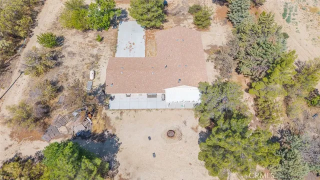 an aerial view of house with yard and trees