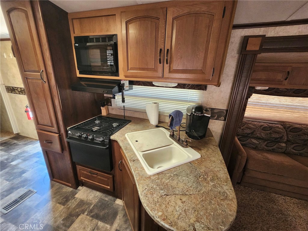 38855 Howard Road Anza, CA 92539 - Photo 51 of 54 a kitchen with granite countertop a stove and a refrigerator
