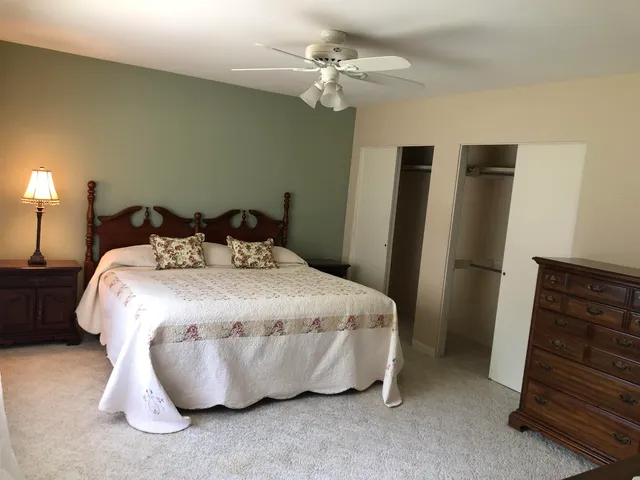 a large bed sitting in a room next to a window