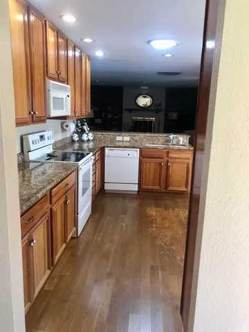 a large kitchen with stainless steel appliances granite countertop a large stove a sink and a microwave