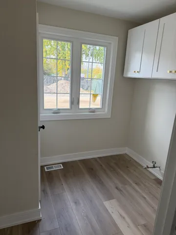 an empty room with wooden floor and windows