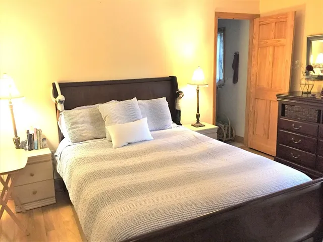 a large bed sitting in a bedroom next to a window