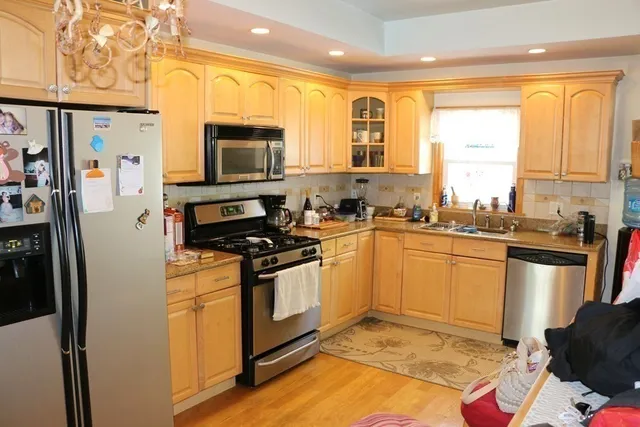 a kitchen with stainless steel appliances granite countertop a stove a sink and a refrigerator