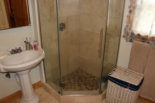 a bathroom with a sink a toilet and shower