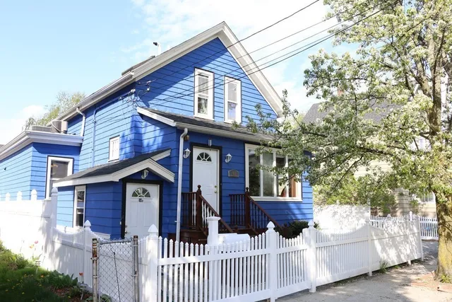 a view of a house with wooden fence and trees