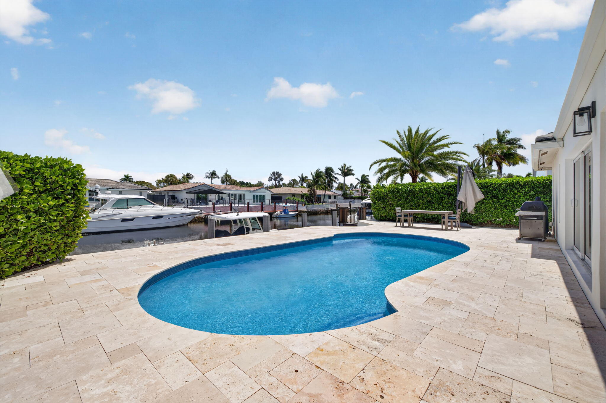 4460 Northeast 26th Avenue Lighthouse Point, FL 33064 - Photo 35 of 55 a view of a swimming pool with a lawn chairs and potted plants
