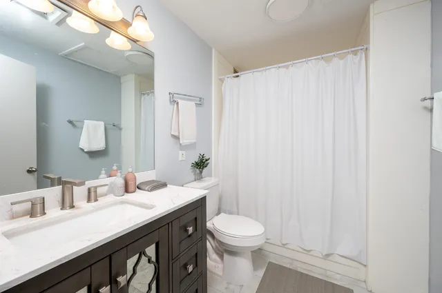 a bathroom with a sink a toilet and a mirror