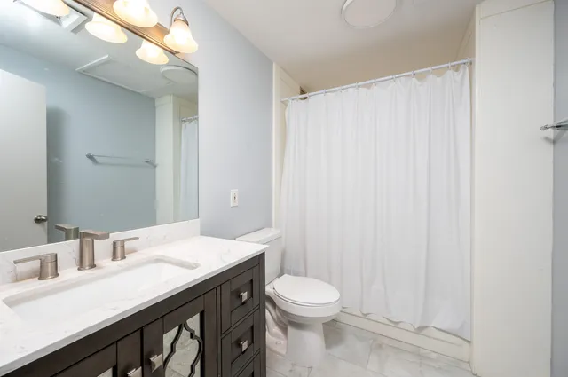 a view of a bathroom with a tub and a view of bedroom