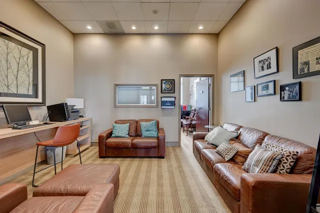 a dining room with furniture and potted plants