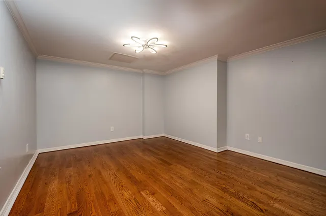 a kitchen with stainless steel appliances granite countertop a refrigerator a stove a sink dishwasher and white cabinets with wooden floor