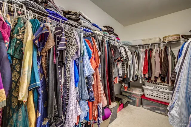 a view of walk in closet with clothes