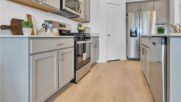 a kitchen with stainless steel appliances granite countertop a refrigerator a stove and a sink with wooden floor