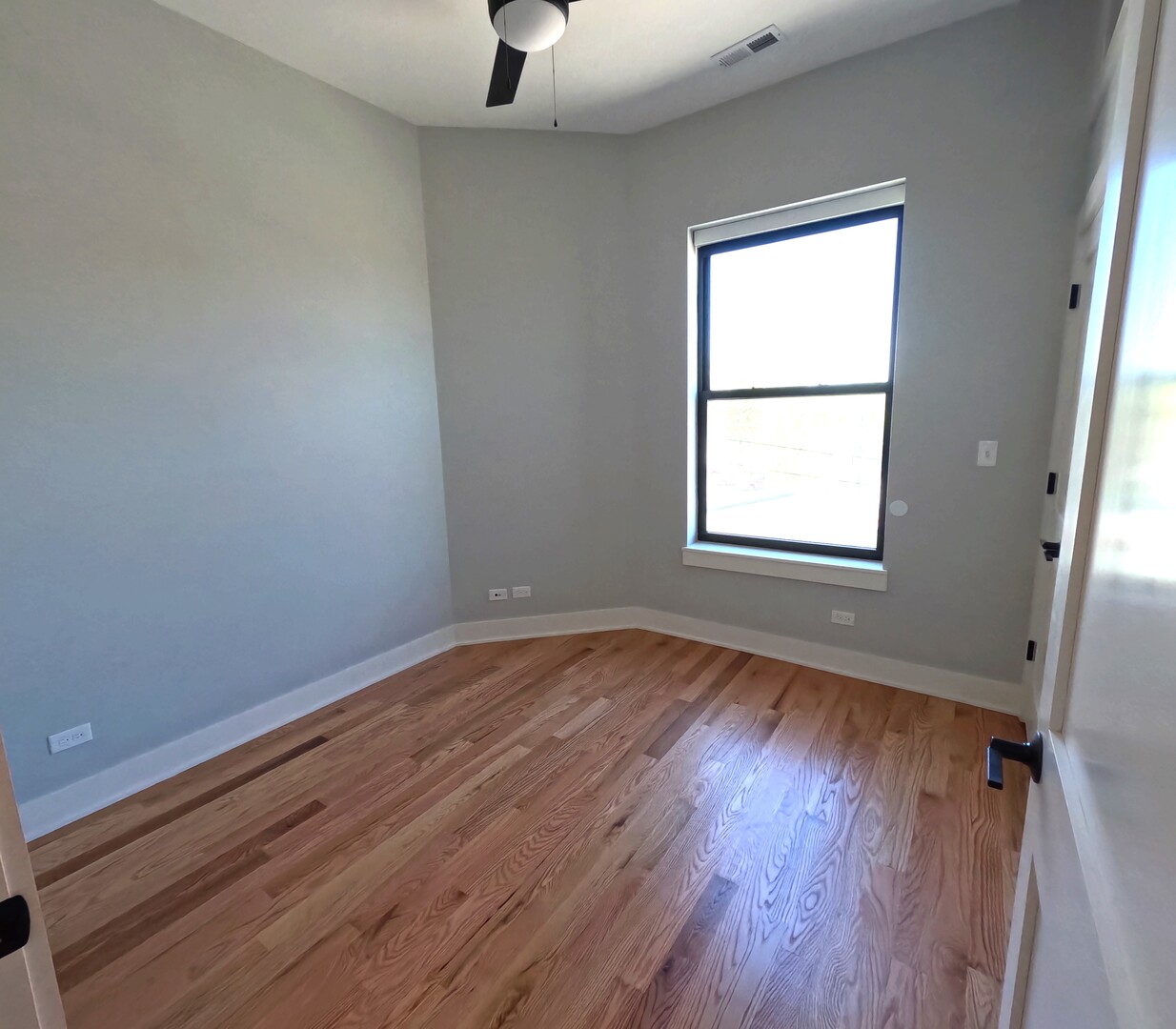 3473 South Archer Avenue, Unit 301 Chicago, IL 60608 - Photo 10 of 13 a view of an empty room with wooden floor and a window