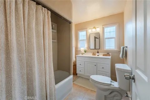 a bathroom with a toilet a sink a tub and mirror