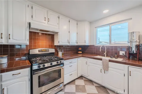 a kitchen with granite countertop a sink stainless steel appliances and cabinets