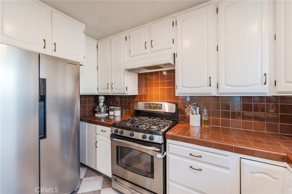 1931 West 68th Street Los Angeles, CA 90047 - Photo 17 of 29 a kitchen with stainless steel appliances granite countertop a stove a refrigerator and a white cabinets