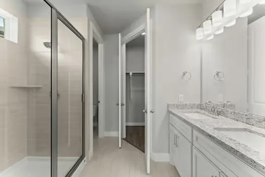 a bathroom with a granite countertop sink a mirror and a shower