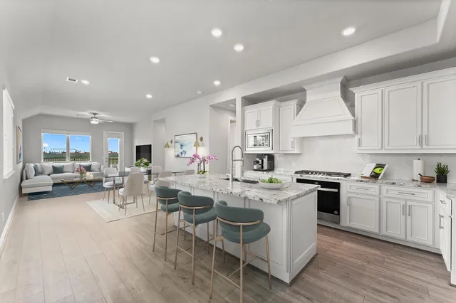 a kitchen with a sink a stove top oven a stove and white cabinets