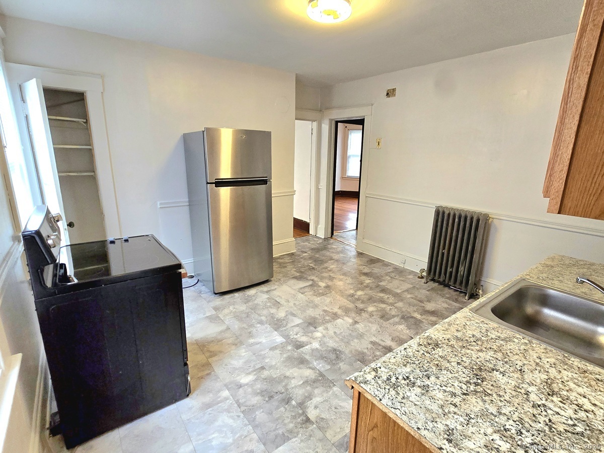 181 Bond Street, Unit 1 Hartford, CT 06114 - Photo 2 of 12 a kitchen with stainless steel appliances kitchen island granite countertop a refrigerator and a stove