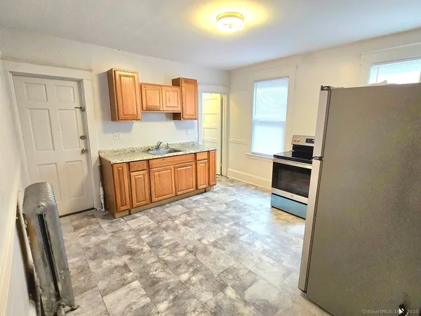 a kitchen with granite countertop a refrigerator and a sink