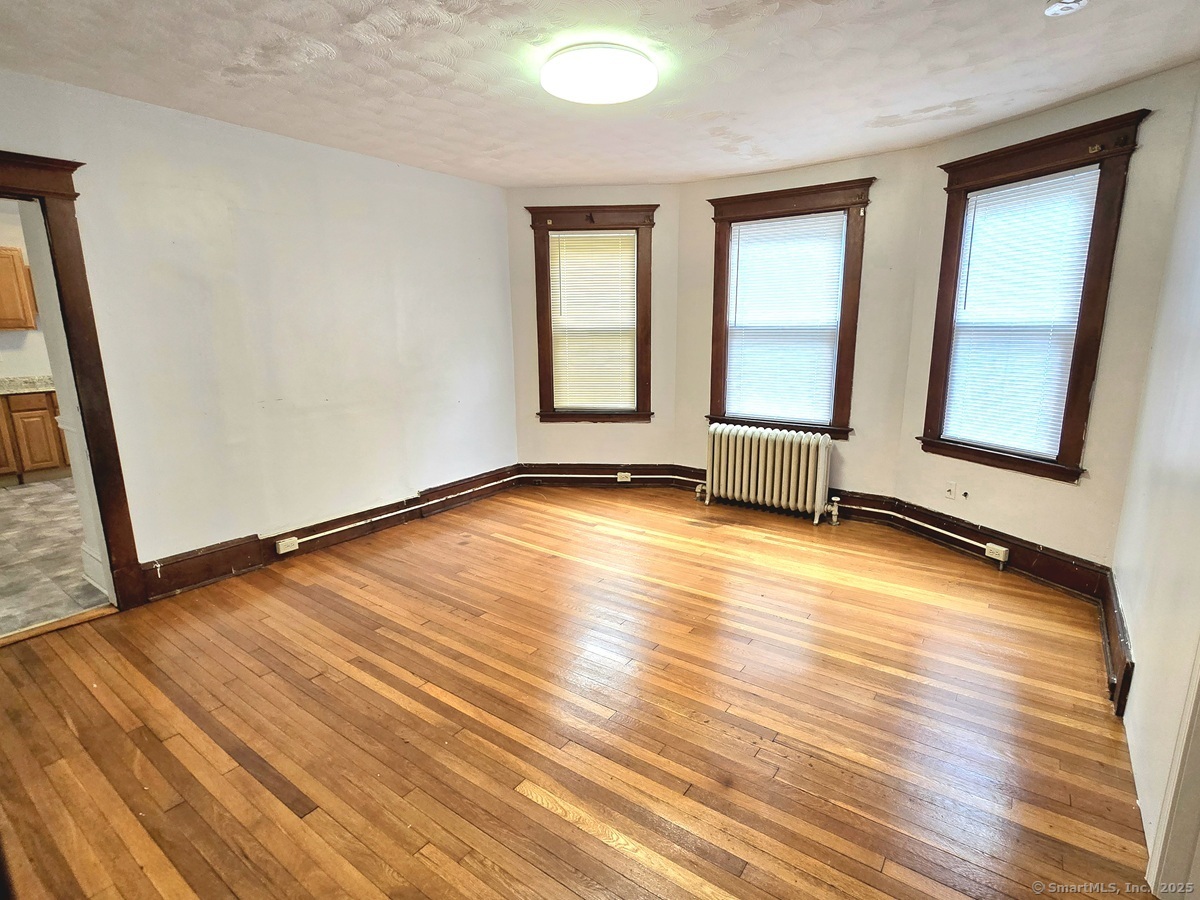 181 Bond Street, Unit 1 Hartford, CT 06114 - Photo 4 of 12 a view of an empty room with wooden floor and a window