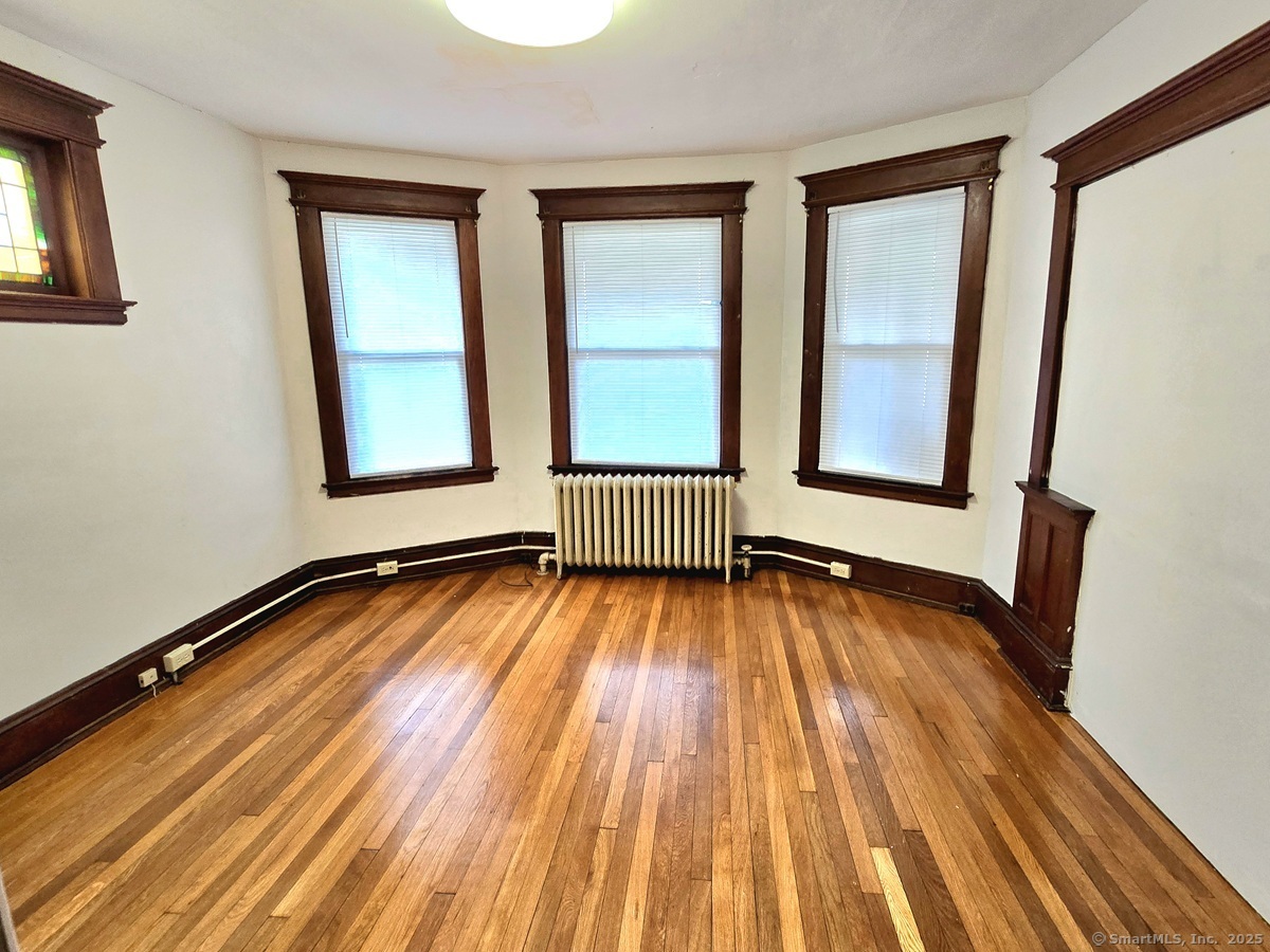 181 Bond Street, Unit 1 Hartford, CT 06114 - Photo 5 of 12 an empty room with wooden floor and windows