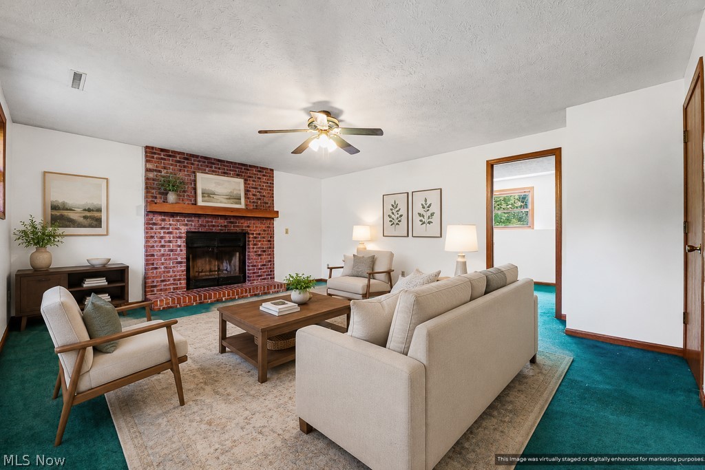 2642 Blake Road Wadsworth, OH 44281 - Photo 9 of 46 Living area featuring a brick fireplace with a wood mantel, white walls, and a ceiling fan