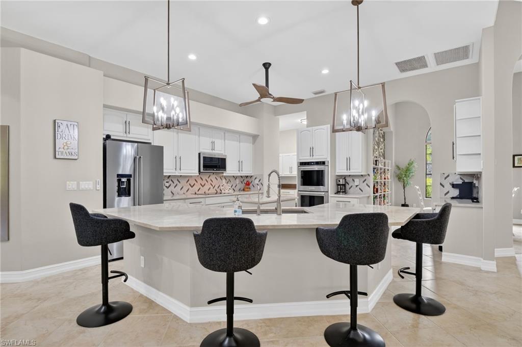 2360 19th Street Southwest Naples, FL 34117 - Photo 12 of 43 a living room with furniture and a chandelier