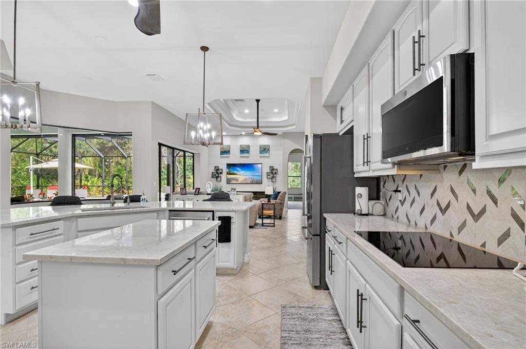 2360 19th Street Southwest Naples, FL 34117 - Photo 15 of 43 a kitchen with stainless steel appliances granite countertop a sink a stove and a wooden floors