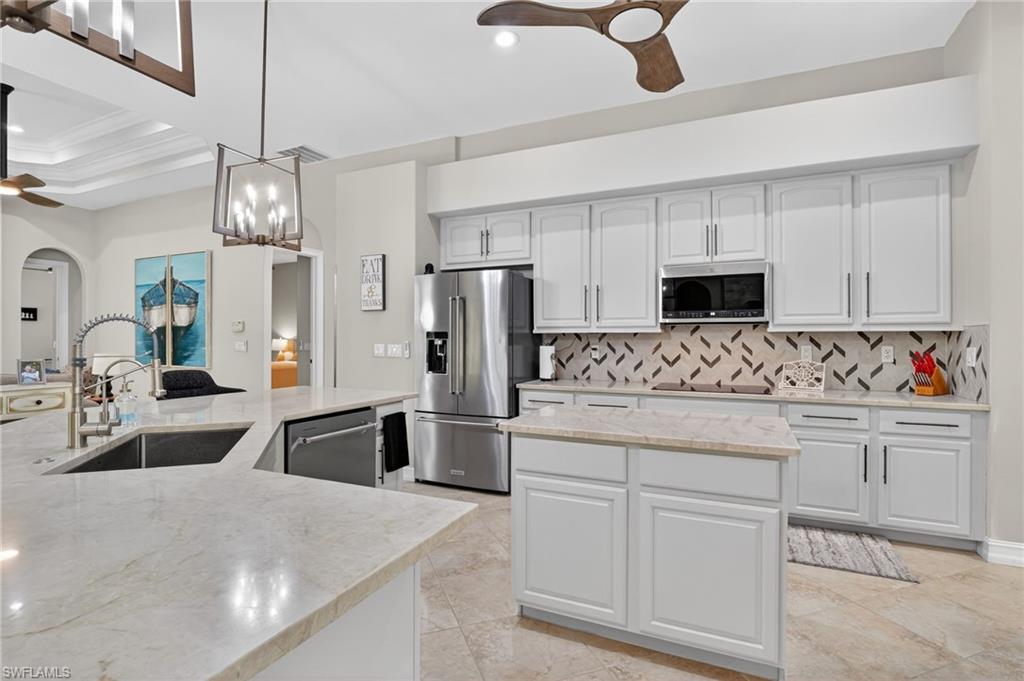 2360 19th Street Southwest Naples, FL 34117 - Photo 17 of 43 a kitchen with white cabinets and stainless steel appliances