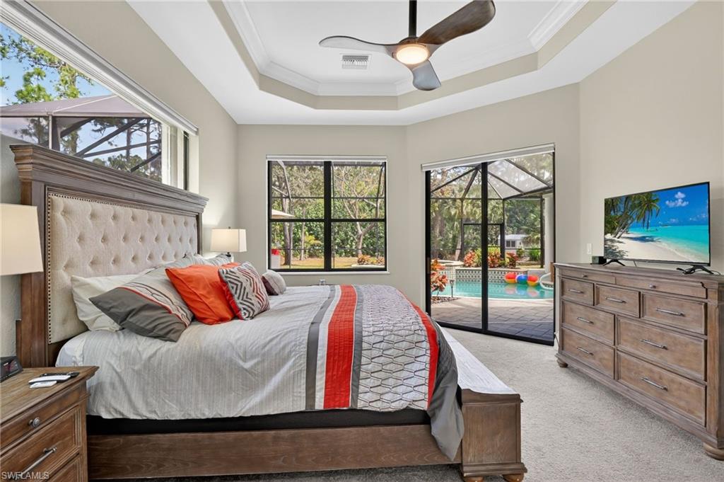 2360 19th Street Southwest Naples, FL 34117 - Photo 21 of 43 a bedroom with a large bed and a flat tv screen on dresser