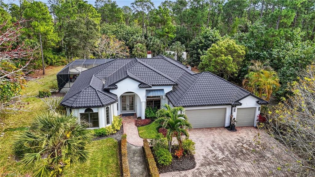 2360 19th Street Southwest Naples, FL 34117 - Photo 2 of 43 a front view of a house with garden