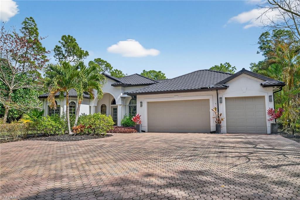2360 19th Street Southwest Naples, FL 34117 - Photo 37 of 43 a front view of a house with a yard and a garage