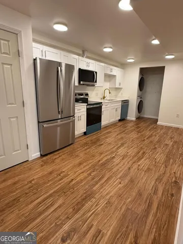 a kitchen with granite countertop a refrigerator and a stove top oven