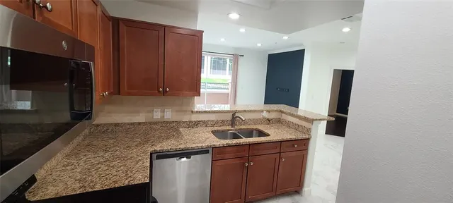 a large kitchen with granite countertop a sink and a stove top oven