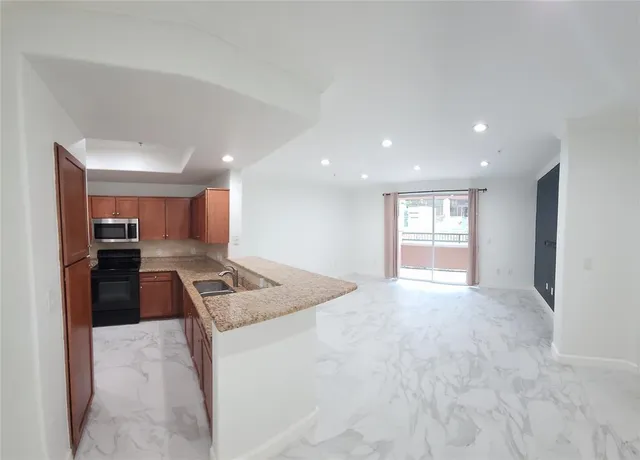 a kitchen with stainless steel appliances granite countertop a refrigerator and a stove