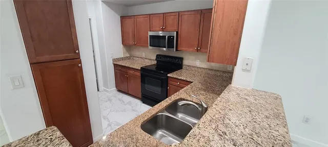 a kitchen with stainless steel appliances granite countertop a stove and a microwave
