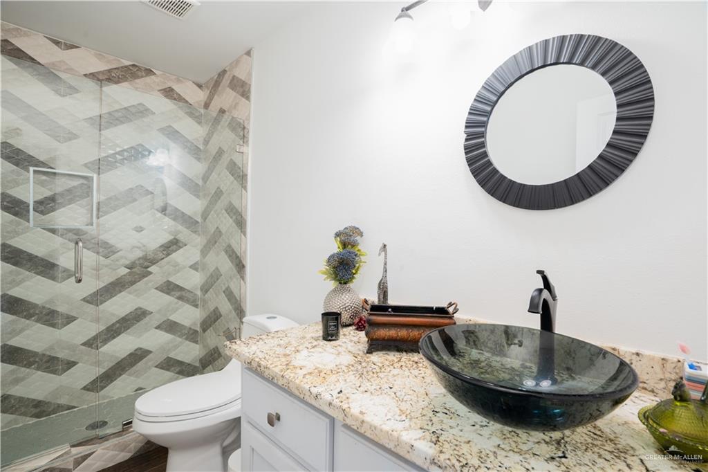 21604 North Val Verde Road Edinburg, TX 78542 - Photo 24 of 39 a bathroom with a granite countertop toilet and a mirror