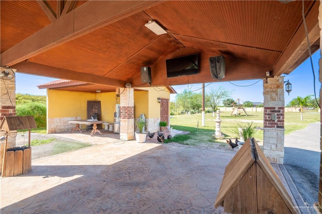 21604 North Val Verde Road Edinburg, TX 78542 - Photo 30 of 39 a view of a patio with a table and chairs under an umbrella