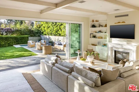 a living room with furniture fireplace and a large window
