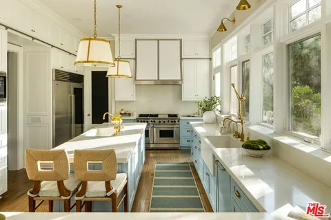 a kitchen with stainless steel appliances kitchen island granite countertop a stove a sink and a refrigerator