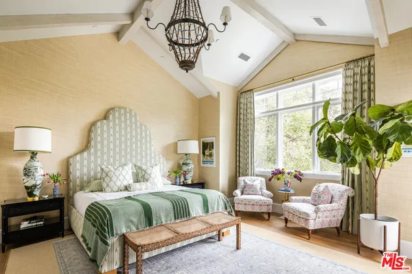 a bedroom with a bed a chandelier and a fireplace
