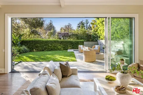 a living room with a floor to ceiling window and pool table