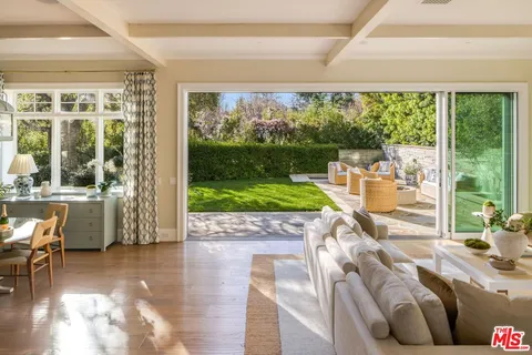 a living room with furniture fireplace and a large window